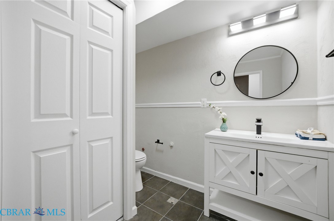 733 Spruce Street Hampton, VA 23661 - Photo 19 of 29 Bathroom featuring vanity, dark tile patterned flooring, and a closet