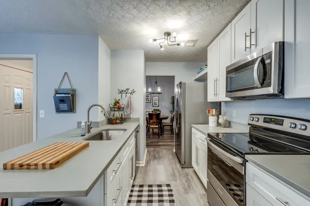 a kitchen with stainless steel appliances granite countertop a sink stove and refrigerator