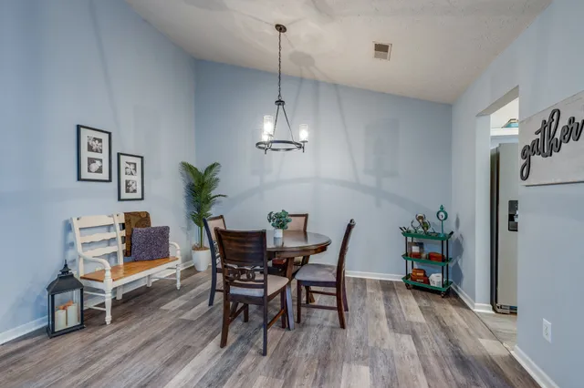 a view of a dining room with furniture wooden floor and a chandelier