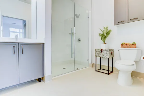 a bathroom with a granite countertop sink a toilet and a mirror