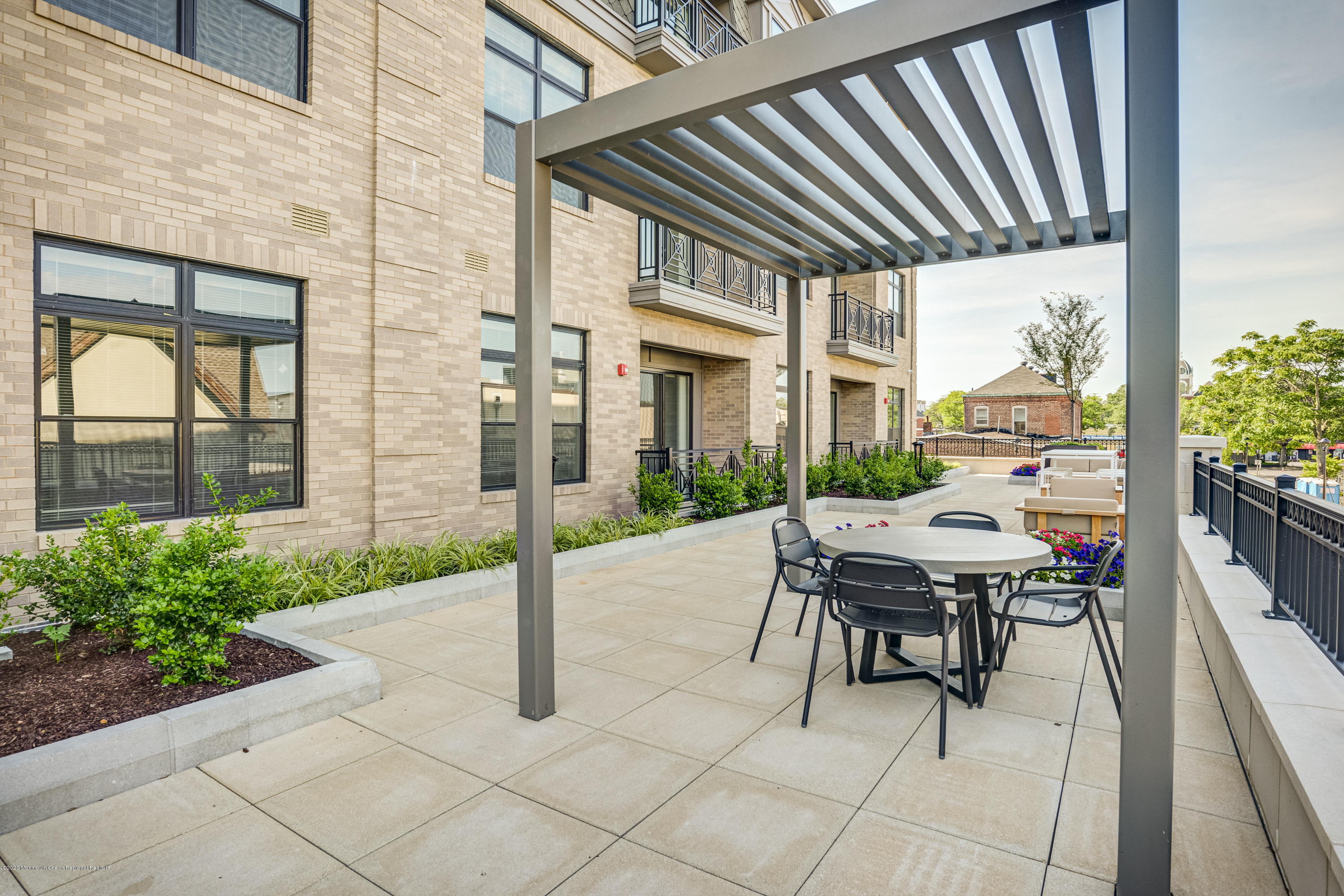 55 West Front Street, Unit 301 Red Bank, NJ 07701 - Photo 24 of 26 a patio with table and chairs and potted plants