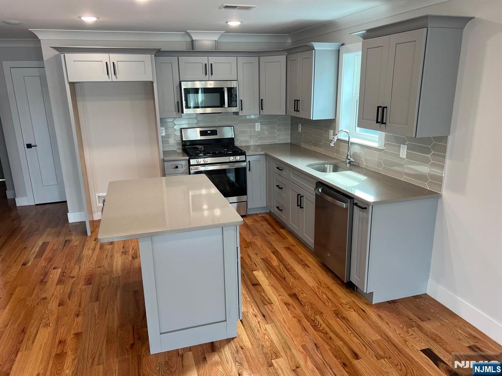 1060 Magnolia Avenue Elizabeth, NJ 07201 - Photo 10 of 22 a kitchen with stainless steel appliances a stove top oven a sink and a refrigerator