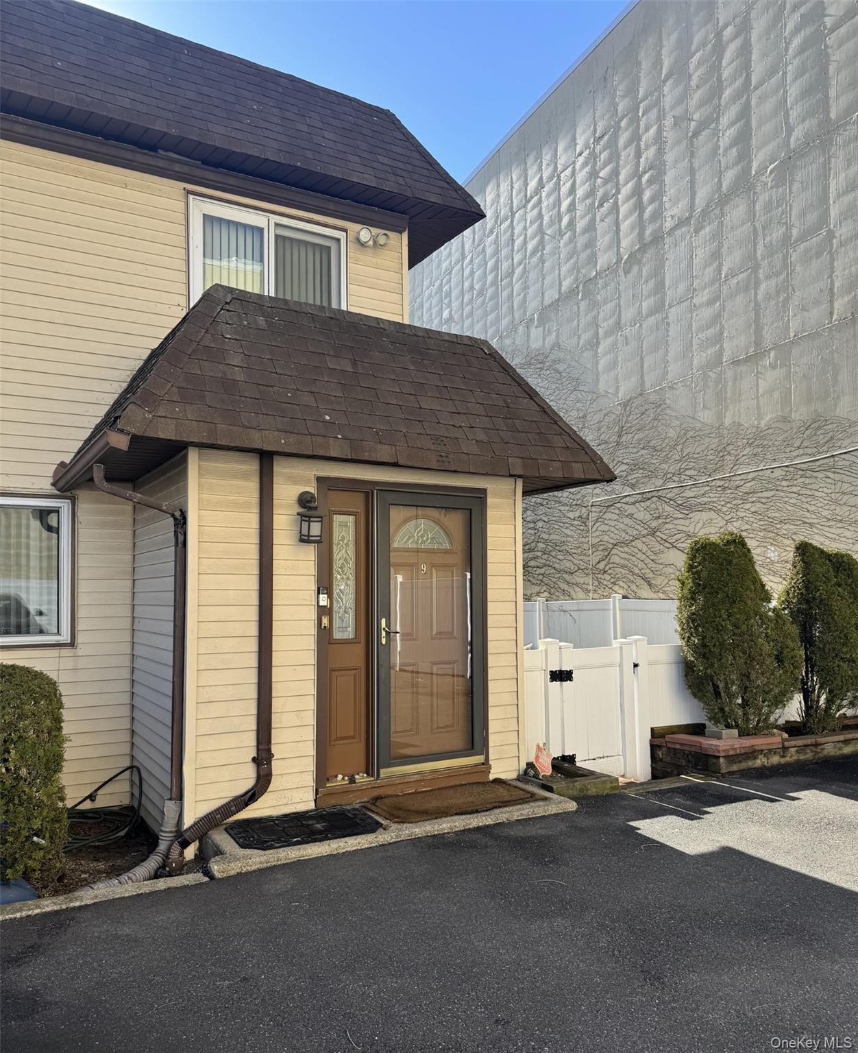 88 East Valley Stream Boulevard, Unit 9 Valley Stream, NY 11580 - Photo 1 of 17 a front view of a house with a yard and garage