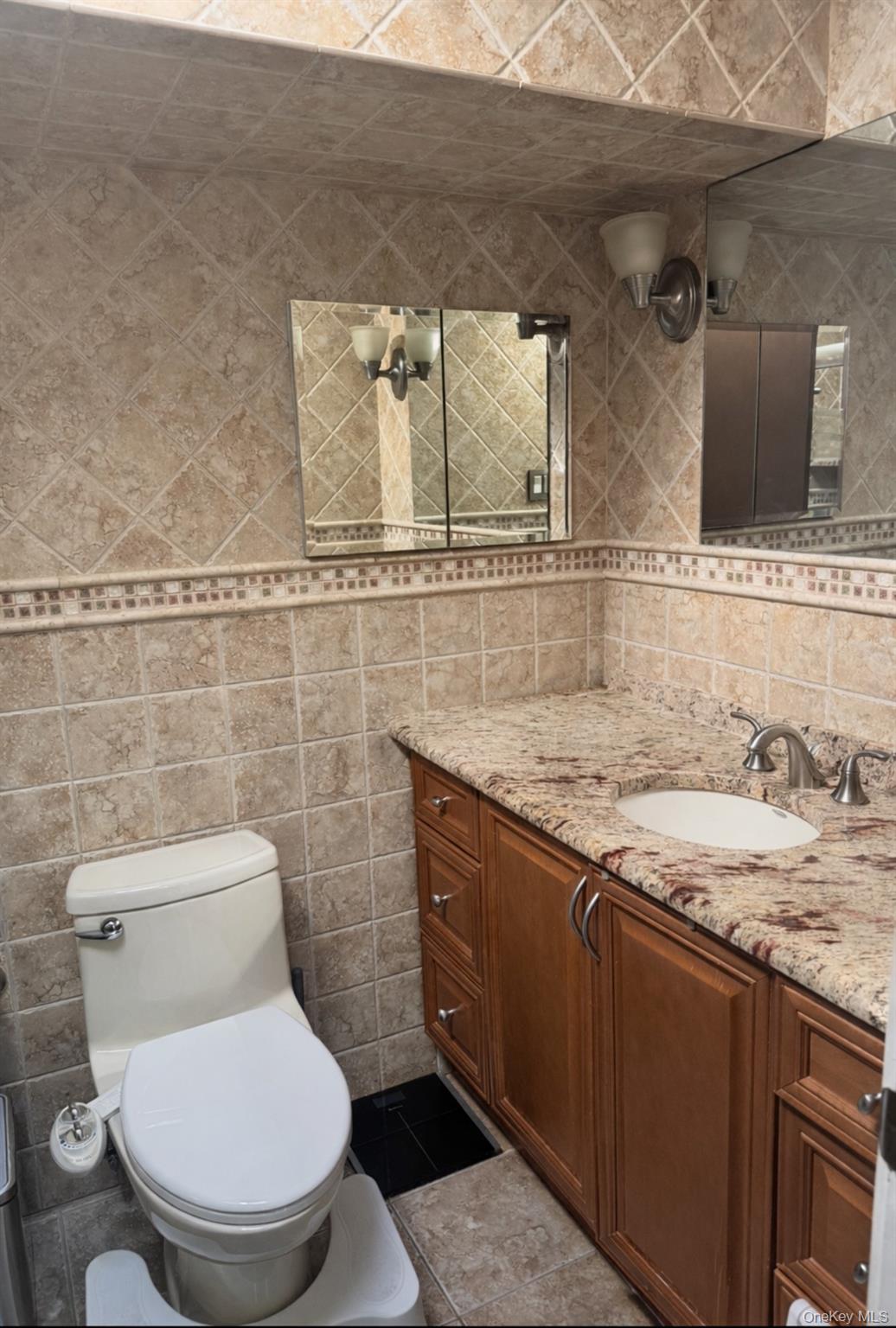 88 East Valley Stream Boulevard, Unit 9 Valley Stream, NY 11580 - Photo 14 of 17 a bathroom with a granite countertop toilet sink and mirror