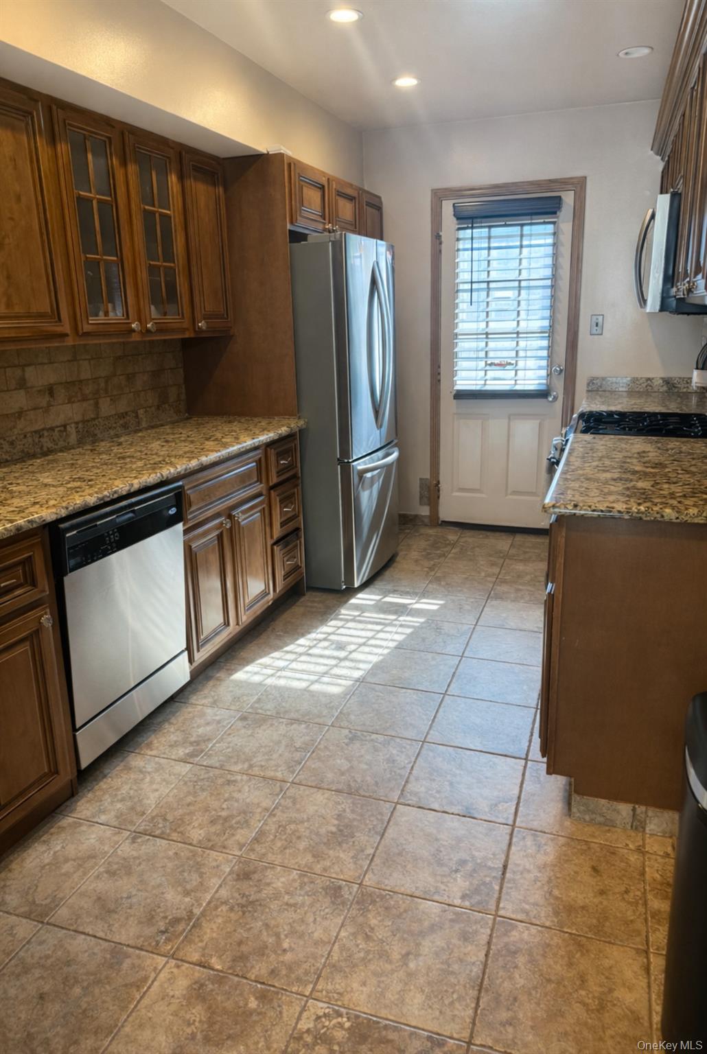 88 East Valley Stream Boulevard, Unit 9 Valley Stream, NY 11580 - Photo 7 of 17 a kitchen with stainless steel appliances granite countertop a stove a sink and a microwave