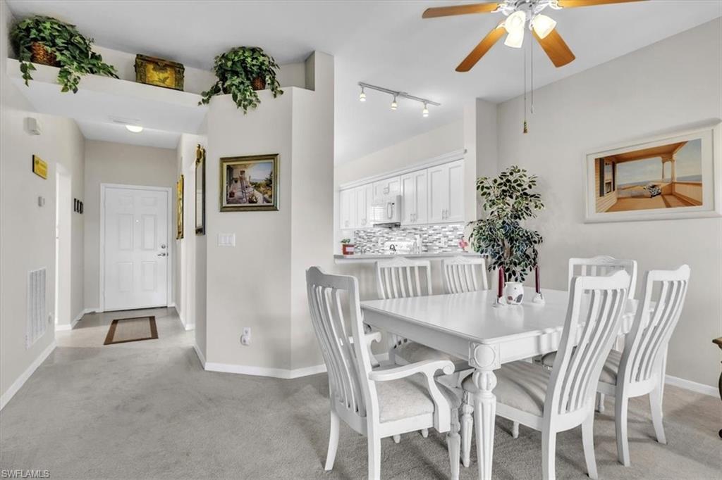 8075 Tiger Cove, Unit 1706 Naples, FL 34113 - Photo 7 of 50 Dining space with light carpet and ceiling fan