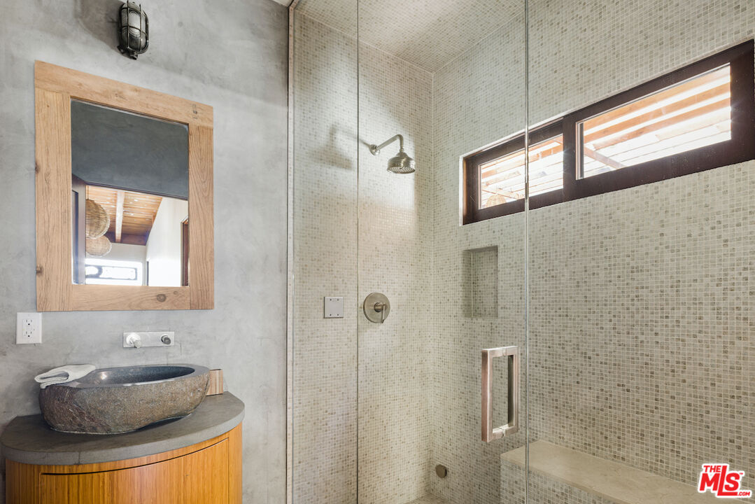 473 West Rustic Road Santa Monica, CA 90402 - Photo 14 of 25 a bathroom with a granite countertop sink a mirror and shower