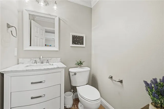 a bathroom with a granite countertop toilet sink and mirror