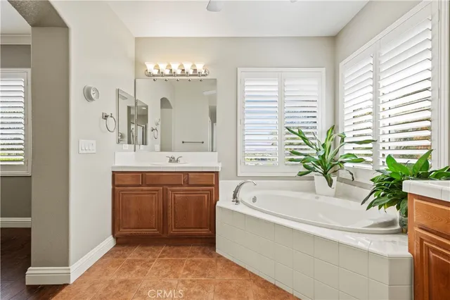 a spacious bathroom with a tub sink and mirror
