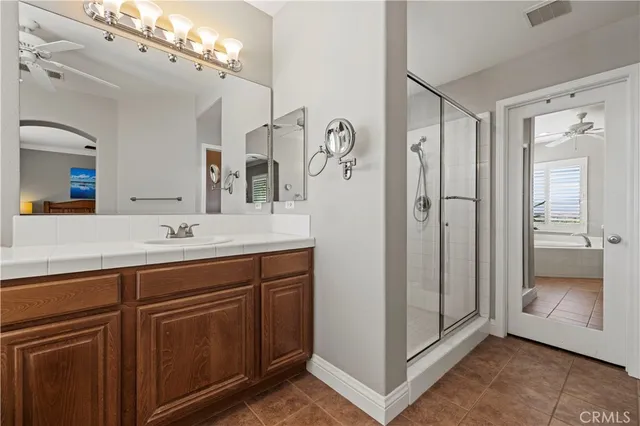 a spacious bathroom with a shower sink and mirror