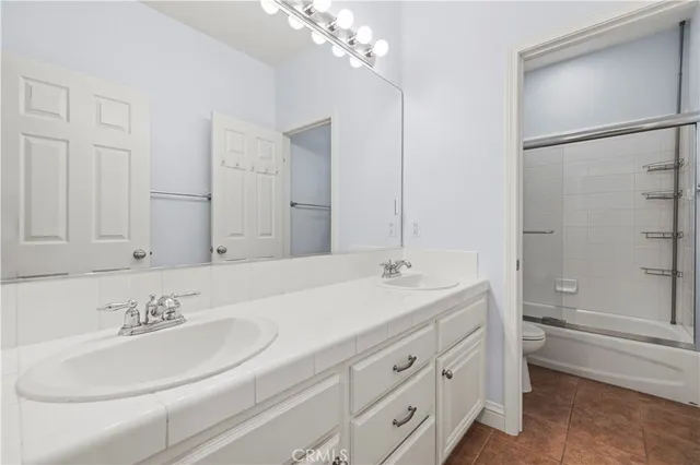 a bathroom with a sink double vanity granite tub and shower