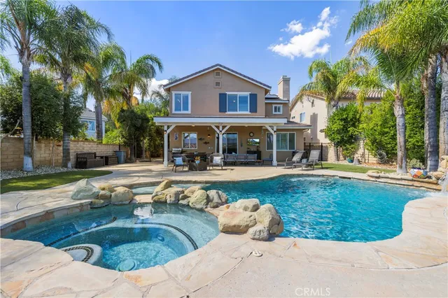 a view of a house with swimming pool and sitting area
