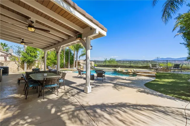 a view of a patio with a table and chairs under an umbrella