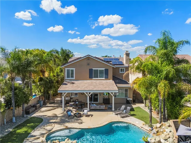 a view of a house with backyard water fountain and sitting area