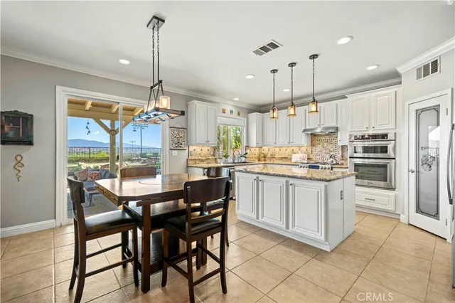 a kitchen with kitchen island white cabinets and refrigerator