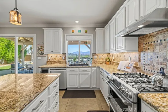 a kitchen with stainless steel appliances granite countertop a stove a sink dishwasher and cabinets with wooden floor