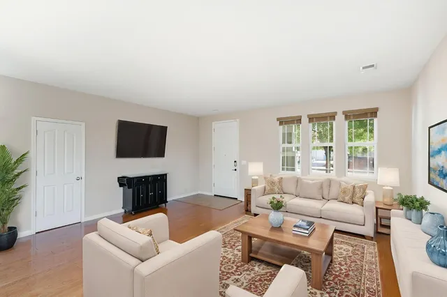 a living room with furniture a flat screen tv and a large window