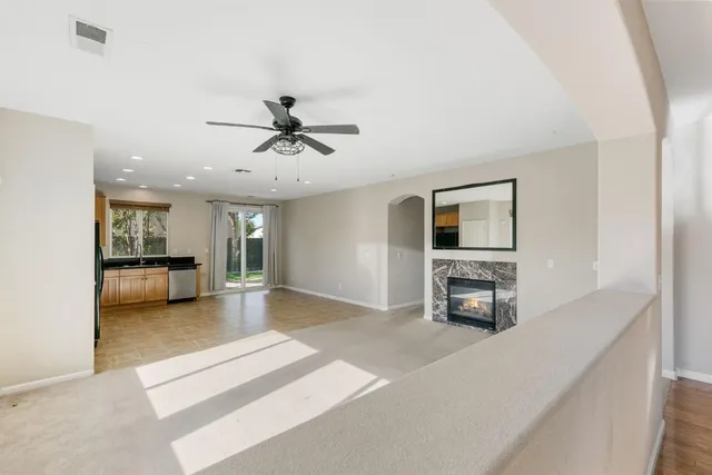 a view of a livingroom with a flat screen tv a ceiling fan and a kitchen