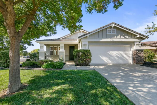 a front view of a house with a garden and plants