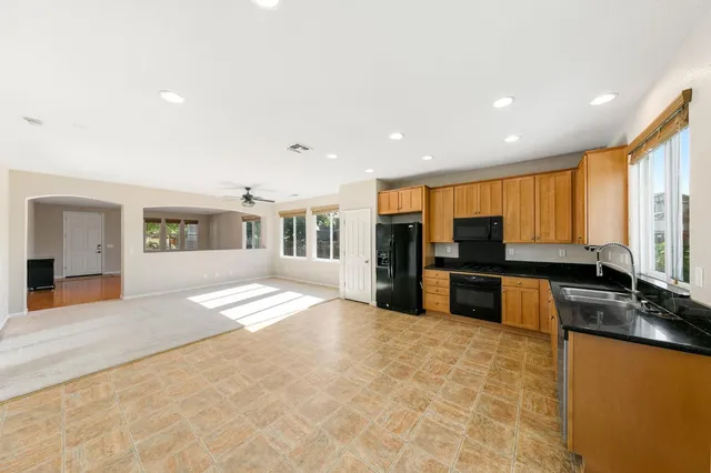 a large kitchen with stainless steel appliances granite countertop a refrigerator and stove