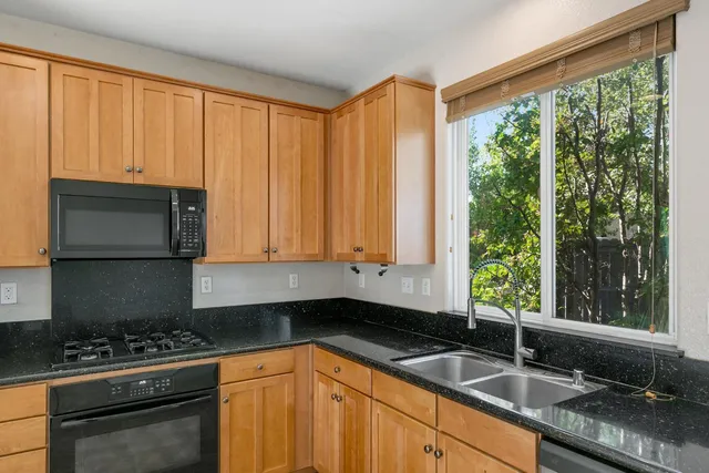 a kitchen with granite countertop a sink stainless steel appliances and a counter space