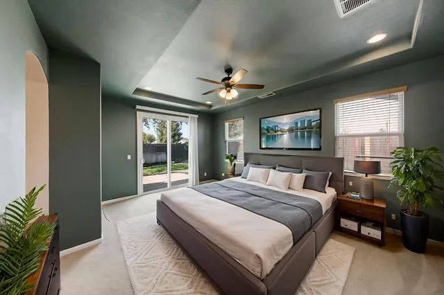 a spacious bedroom with a bed and a flat screen tv