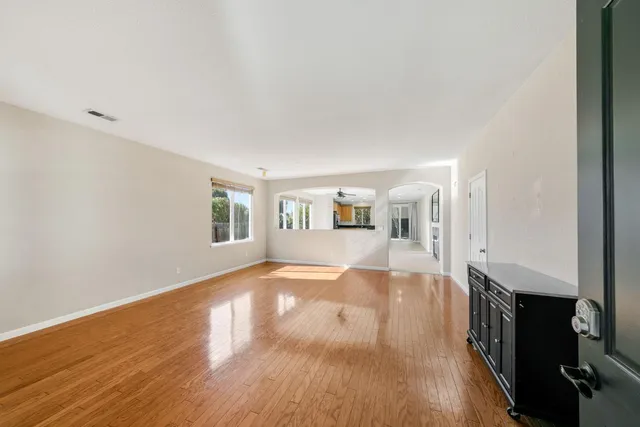 a view of a living room hardwood floor and a kitchen