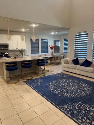 a kitchen with a sink a counter and chairs in it