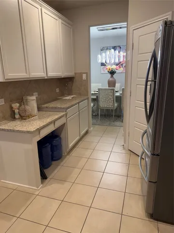 a view of an empty room with chandelier fan