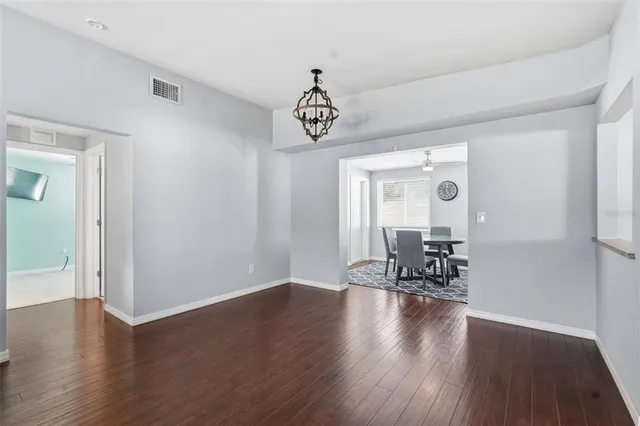 a view of a room with wooden floor table and chairs
