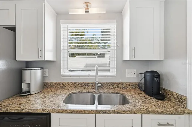 a kitchen with granite countertop a sink and a stove