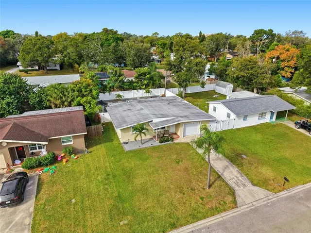 an aerial view of residential houses with outdoor space and trees