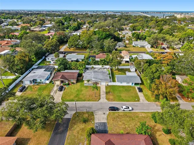 an aerial view of residential houses with outdoor space and parking