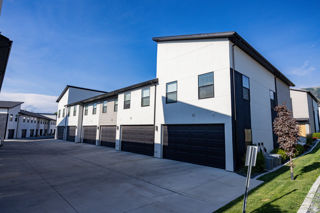 220 Spring Creek Parkway Providence, UT 84332 - Photo 19 of 26 Modern townhome-style residences featuring two-car garages, a concrete driveway, and contrasting exterior siding