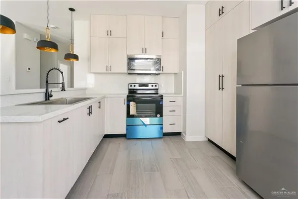 a kitchen with stainless steel appliances granite countertop a sink a stove and refrigerator