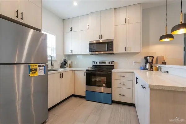 a kitchen with stainless steel appliances a refrigerator sink and white cabinets