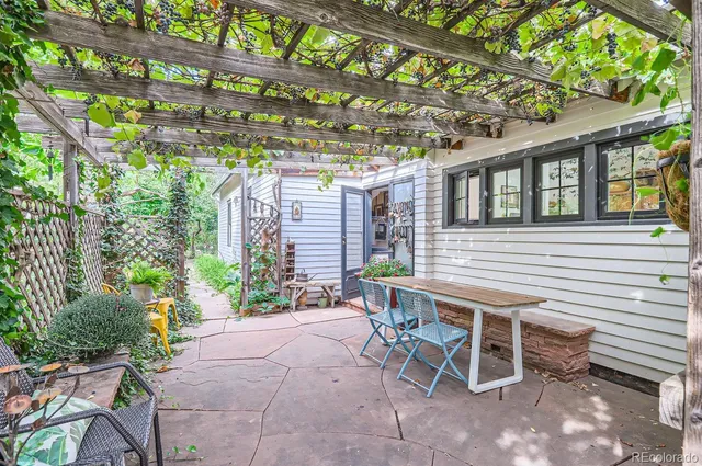 a view of a patio with a table and chairs and potted plants