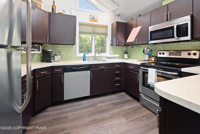 a kitchen with stainless steel appliances granite countertop wooden cabinets a sink and a stove