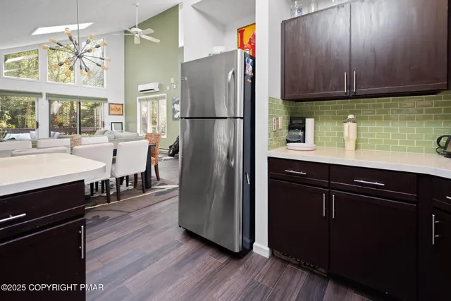 a kitchen with stainless steel appliances granite countertop a refrigerator a stove a sink and dishwasher with wooden floor