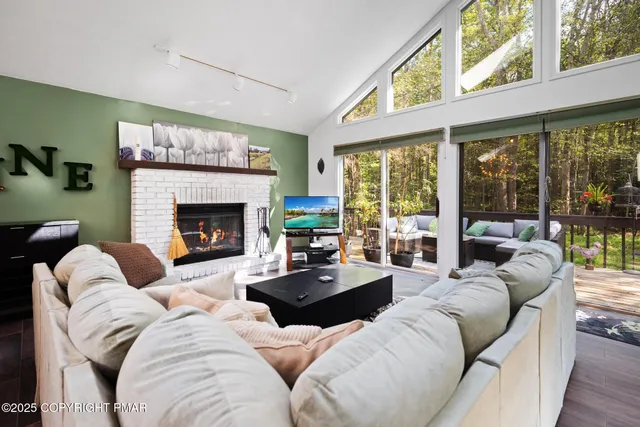 a living room with furniture fireplace and a large window