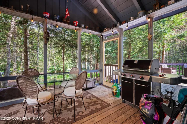 a view of a chairs and table in the patio next to a yard