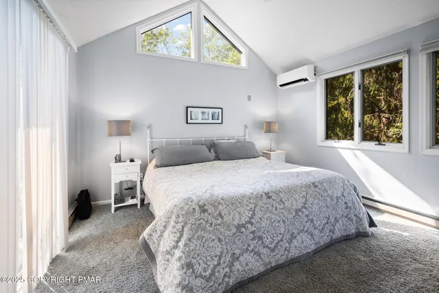 a bedroom with a bed and a large window