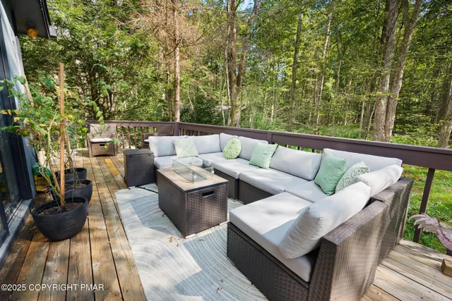 a balcony with couple of couches and potted plants