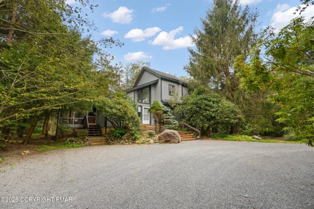 a view of a house with backyard and trees