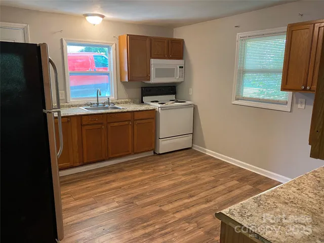 a kitchen with stainless steel appliances granite countertop a refrigerator sink and microwave