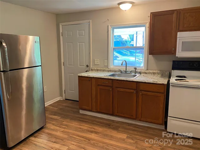 a kitchen with a refrigerator sink and cabinets