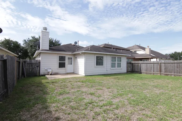 a view of a yard in front of a house with large trees