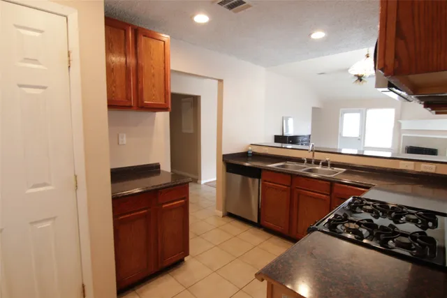 a kitchen with stainless steel appliances granite countertop a stove a sink and a refrigerator