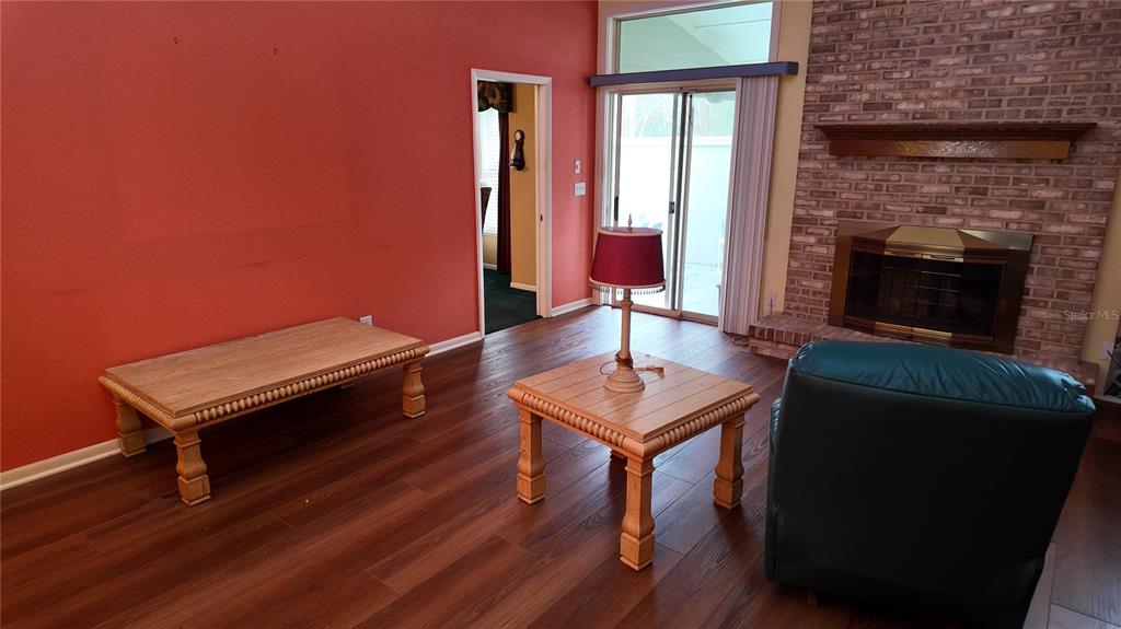 1767 Southeast 27th Loop Ocala, FL 34471 - Photo 25 of 79 a living room with furniture a fireplace and a wooden floor