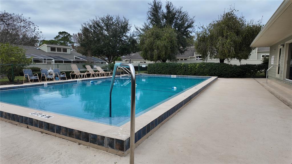 1767 Southeast 27th Loop Ocala, FL 34471 - Photo 74 of 79 a view of a swimming pool with a bench and trees around